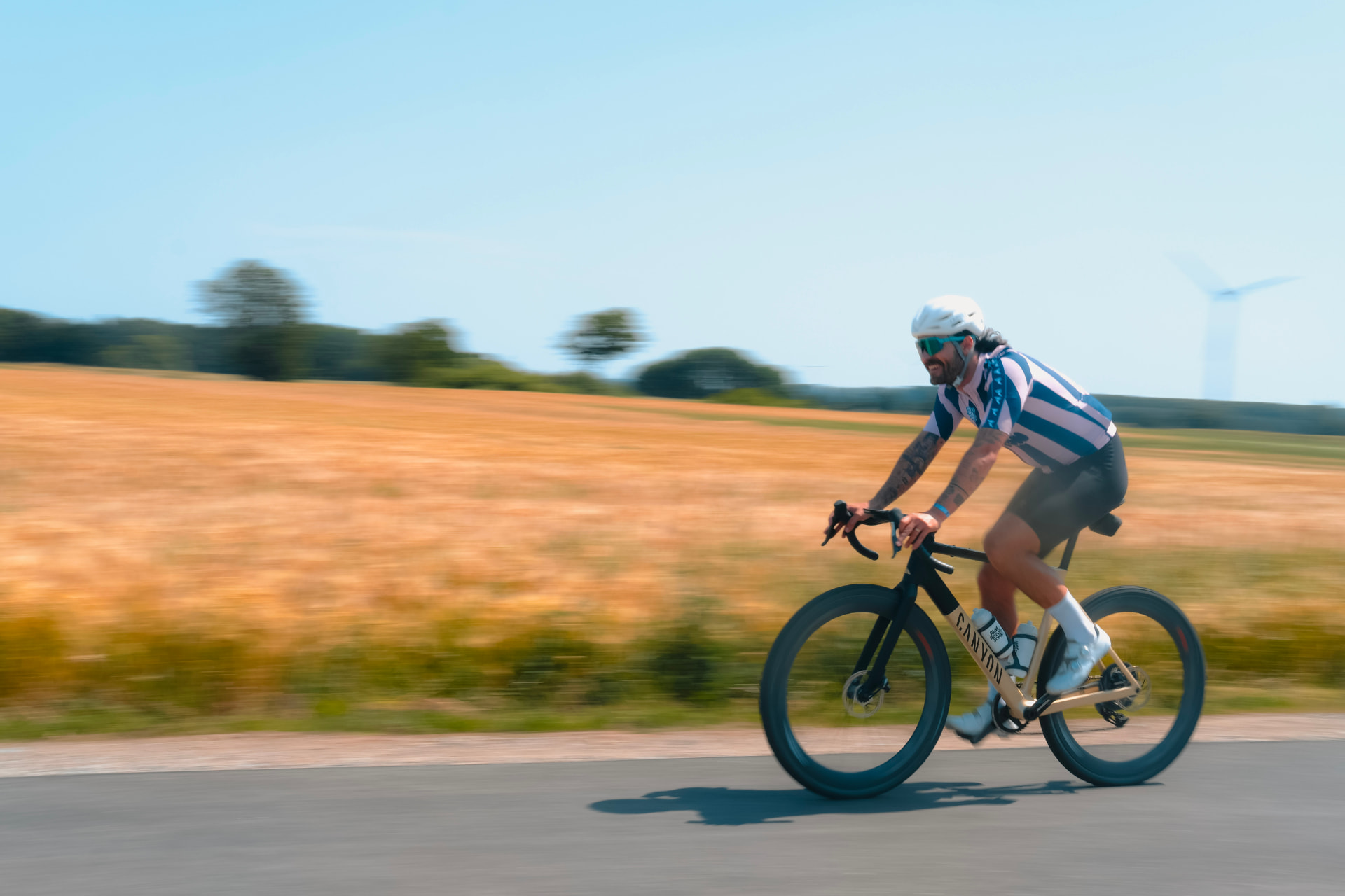 Rennradfahrer des Projekts Seasideride auf einer Landstraße in Mecklenburg-Vorpommern